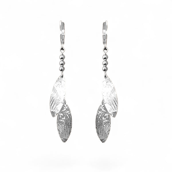 Longues boucles d'oreilles fines avec double pointes en métal martelé argenté, sur fond blanc