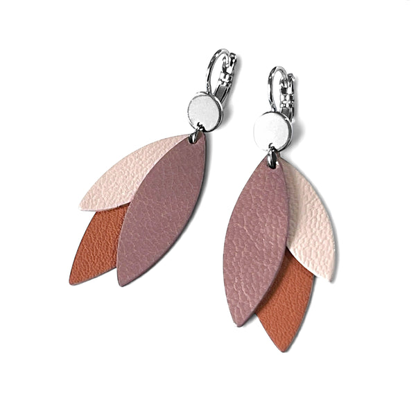 Boucles d'oreilles pendantes argentées et plumes de cuir dans les tons rosés, sur fond blanc