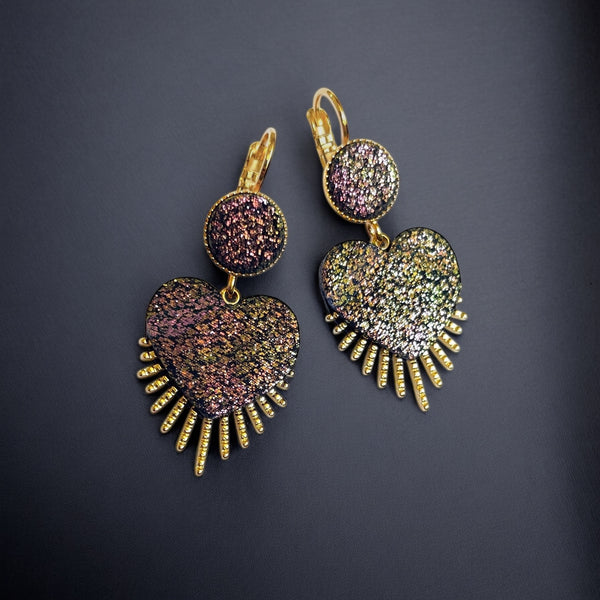 NUNE Boucles d'oreilles dorées en forme de cœurs style ex-voto en cuir pailleté recyclé noir pailleté irisé, sur fond noir