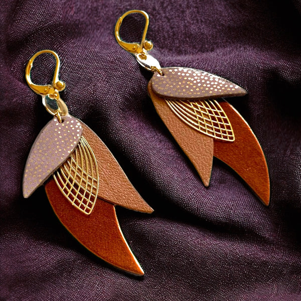 boucles d'oreilles dorées Nune modèle Ara en plumes de cuirs rose Mountbatten pailleté or, camel et chocolat métallisé, sur fond prune