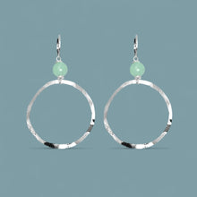 Charger l&#39;image dans la galerie, Boucles d&#39;oreilles créoles de forme ronde en métal martelé argenté et perles de fluorite vert d&#39;eau, sur fond bleu gris
