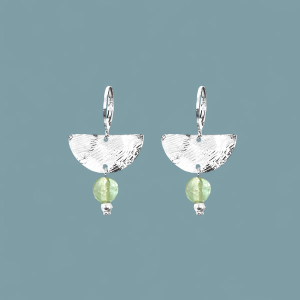 Petites boucles d'oreilles pendantes, de forme demi-lune, en métal martelé argenté et perles de fluorite vert d'eau, sur fond bleu gris