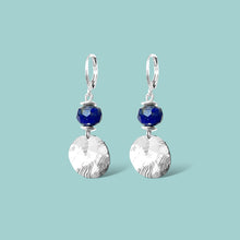 Charger l&#39;image dans la galerie, Petites boucles d&#39;oreilles avec sequin rond en métal martelé argenté et perles de Lapis Lazuli, sur fond vert pastel
