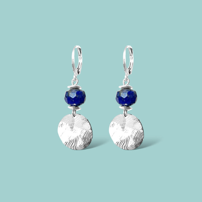 Petites boucles d'oreilles avec sequin rond en métal martelé argenté et perles de Lapis Lazuli, sur fond vert pastel