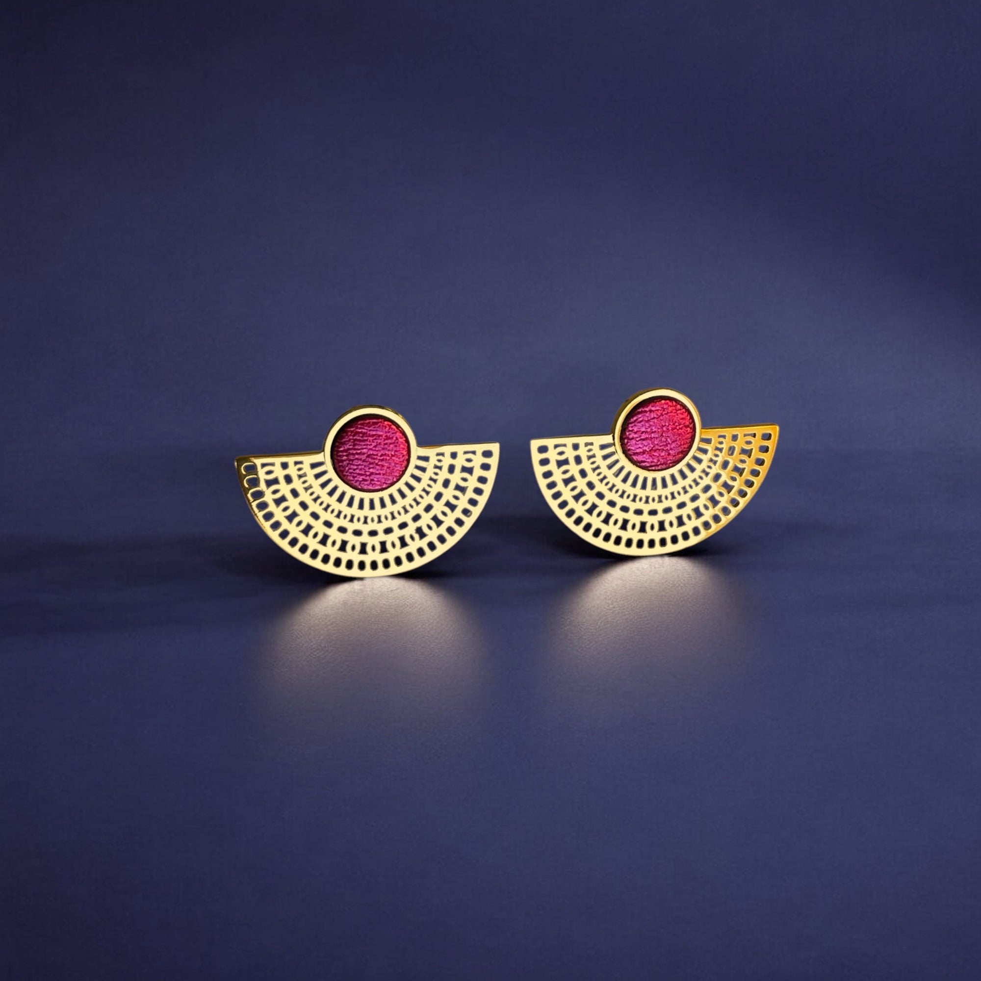 boucles d'oreilles puces dorées Nune modèle Amphea en cuir rose fushia métallisé, sur fond bleu