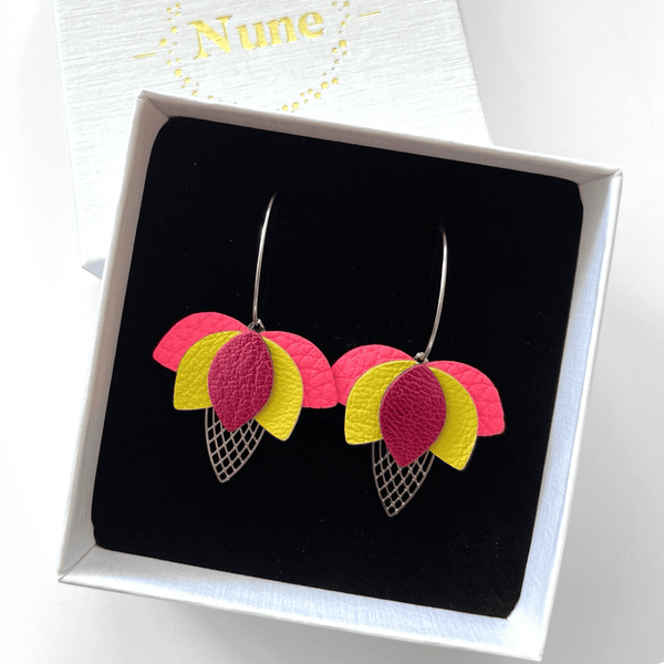 Créoles argentées en forme de fleurs de Lotus en cuirs rose fluo grainé, jaune citron et fushia métallisé sur fond blanc