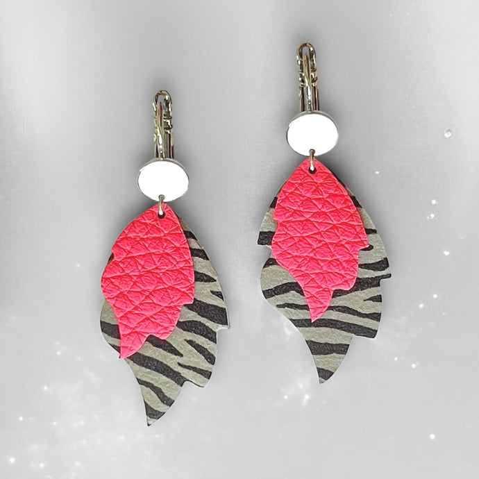 Boucles d'oreilles argentées bohème-chics en forme de flammes en cuir rose fluo grainé et cuir zébré noir, sur fond gris