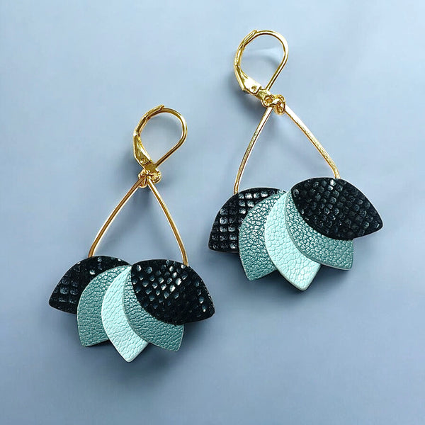 Boucles d'oreilles Nune modèle Aponi dorées à l'or fin avec pétales de cuirs noir et bleu sur fond bleu