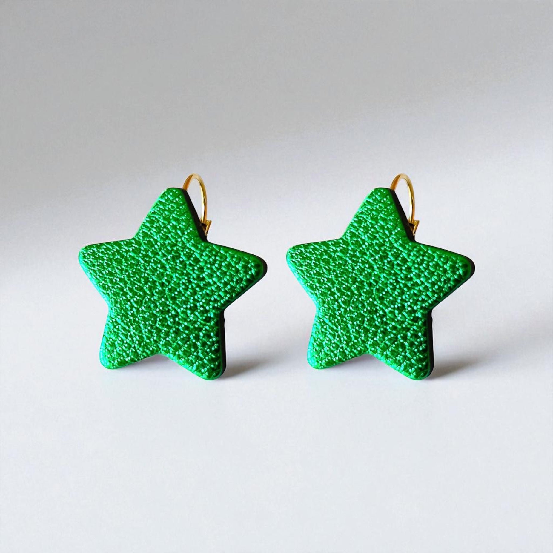 NUNE Boucles d'oreilles Diva en forme d'étoile en cuir recyclé vert métallisé, sur fond gris