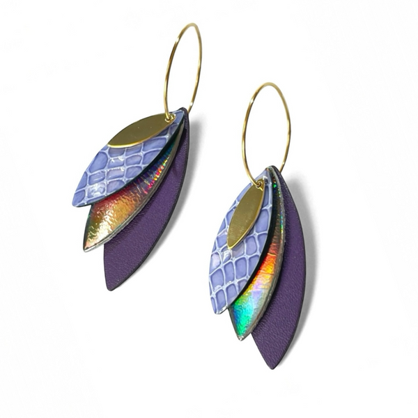 Boucles d'oreilles créoles dorées Nune modèle Piume en cuirs bleu pervenche façon serpent, gris foncé holographique et violet satiné, sur fond blanc