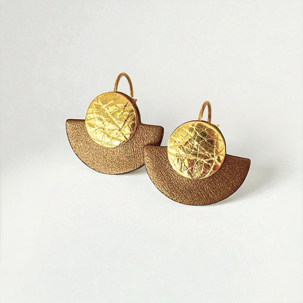 boucles d'oreilles dorées en forme de demi-lunes en cuirs doré et bronze métallisé, sur fond blanc
