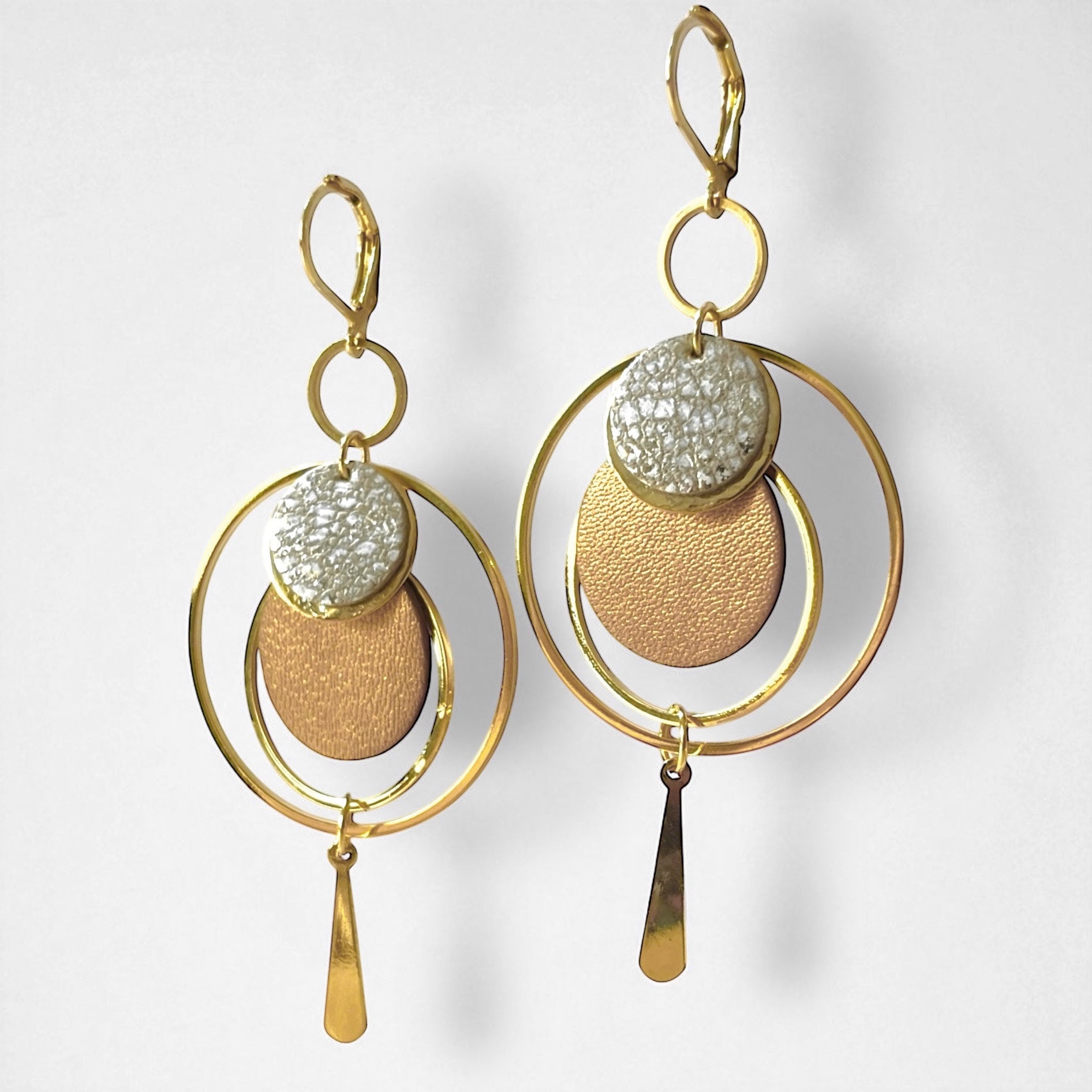 Boucles d'oreilles dorées Nune modèle Galassia en cuirs blanc moucheté or et argent et bronze doré accrochées sur un support en métal doré