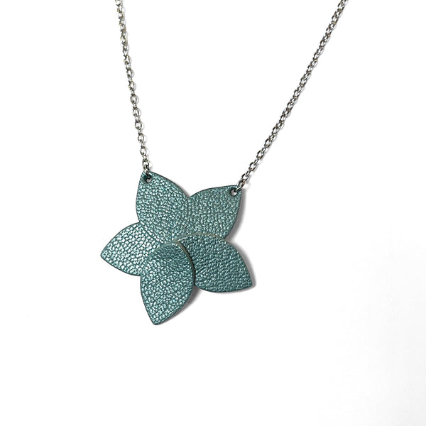 Collier argenté court avec pendentif en cuir bleu gris nacré en forme de fleur, sur fond blanc