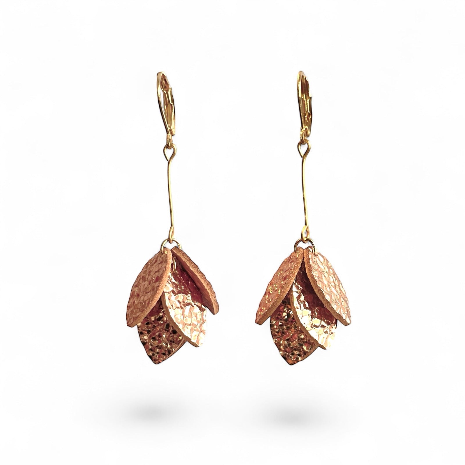 Boucles d'oreilles dorées longues et fines terminées par une grappe de pétales de cuir or rosé froissé, sur fond blanc
