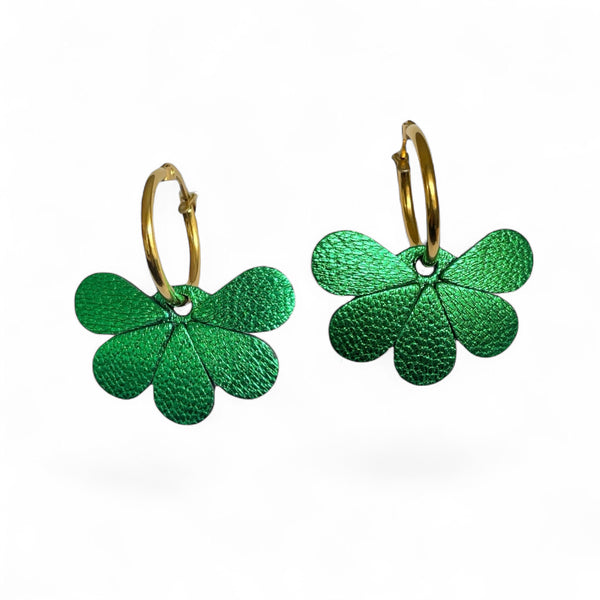Boucles d'oreilles créoles dorées avec pendentifs en cuir vert métallisé en forme de fleurs, sur fond blanc