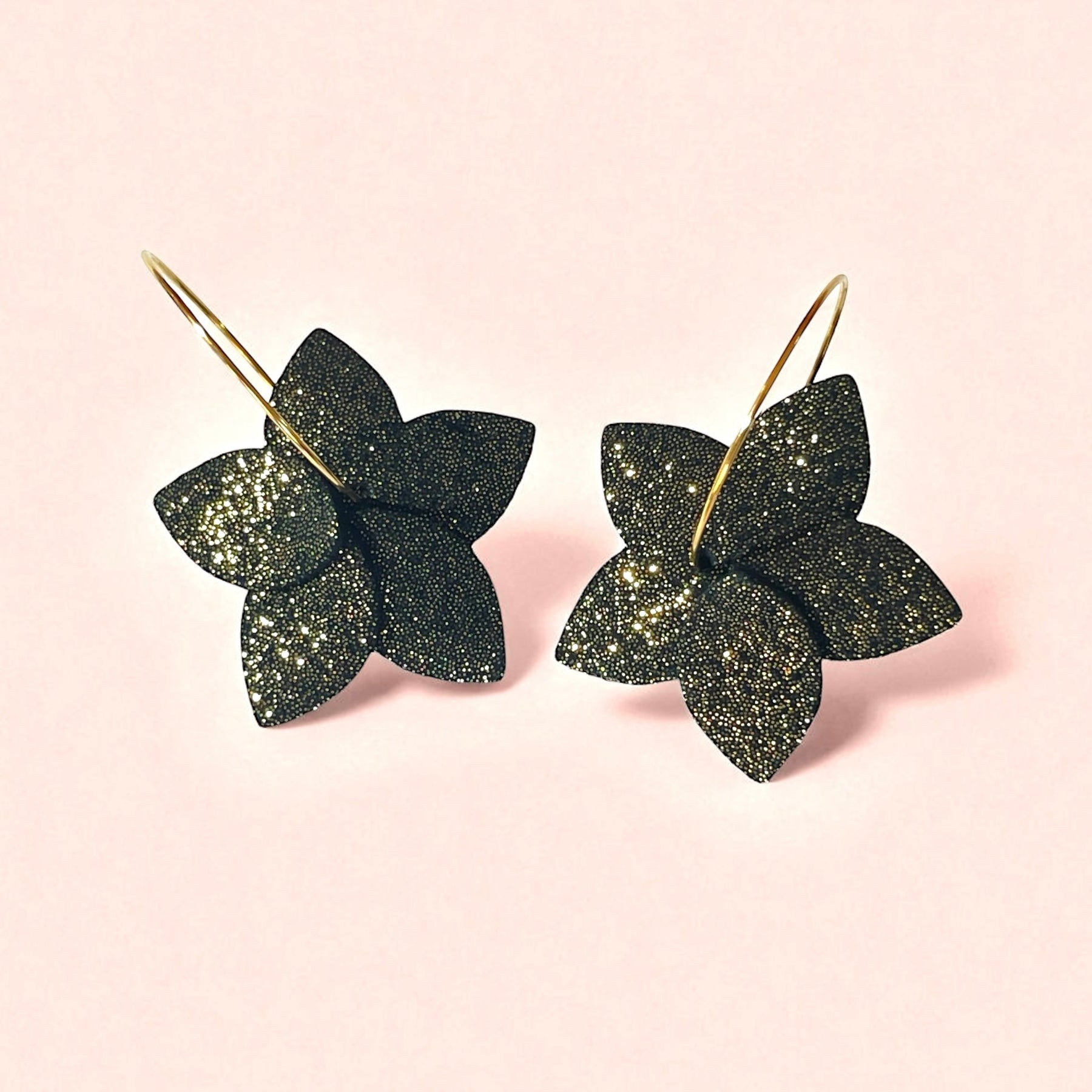 Nune petites boucles d'oreilles créoles Jasmin Pailleté en cuir noir pailleté or et anneaux dorés, vues de dessus, sur fond rosé