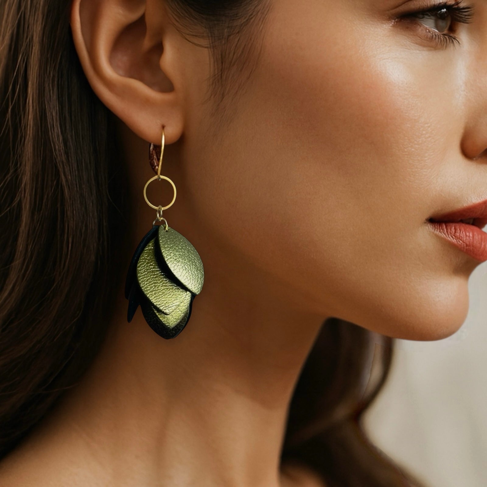 Boucles d’oreilles pendantes en cuir et acier inoxydable doré, de style bohème chic, avec pendentif en feuilles de cuir kaki métallisé superposées, portées aux oreilles