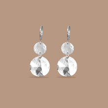 Charger l&#39;image dans la galerie, Petites boucles d&#39;oreilles argentées pendantes avec 2 petits sequins ronds en métal martelé, sur fond beige
