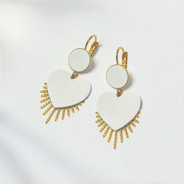 NUNE Boucles d'oreilles dorées Vénus en forme de cœurs style ex-voto en cuir blanc satiné sur fond blanc