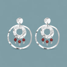 Charger l&#39;image dans la galerie, Grandes boucles d&#39;oreilles puces créoles dorées pendantes longues rondes avec double anneau et petites perles en mokaïte acajou, sur fond bleu gris
