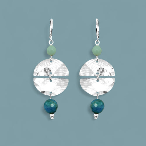 Boucles d'oreilles pendantes de forme ronde avec 2 demi-lunes, en métal martelé argenté et perles d'amazonite et d'apatite bleue, sur fond bleu gris