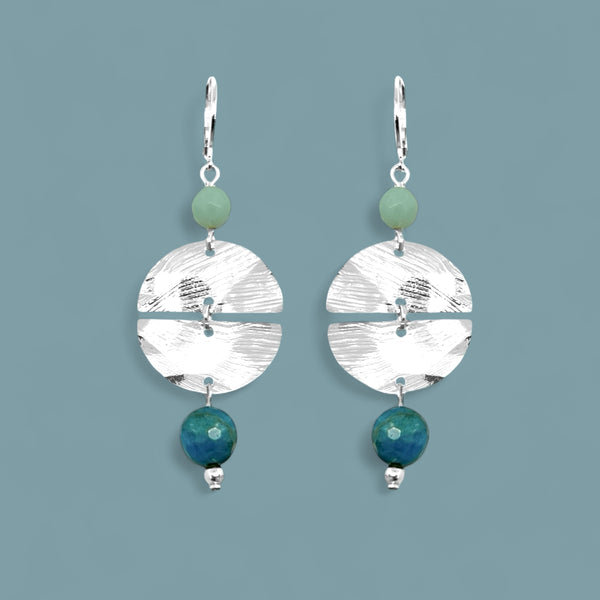 Boucles d'oreilles pendantes de forme ronde avec 2 demi-lunes, en métal martelé argenté et perles d'amazonite et d'apatite bleue, sur fond bleu gris