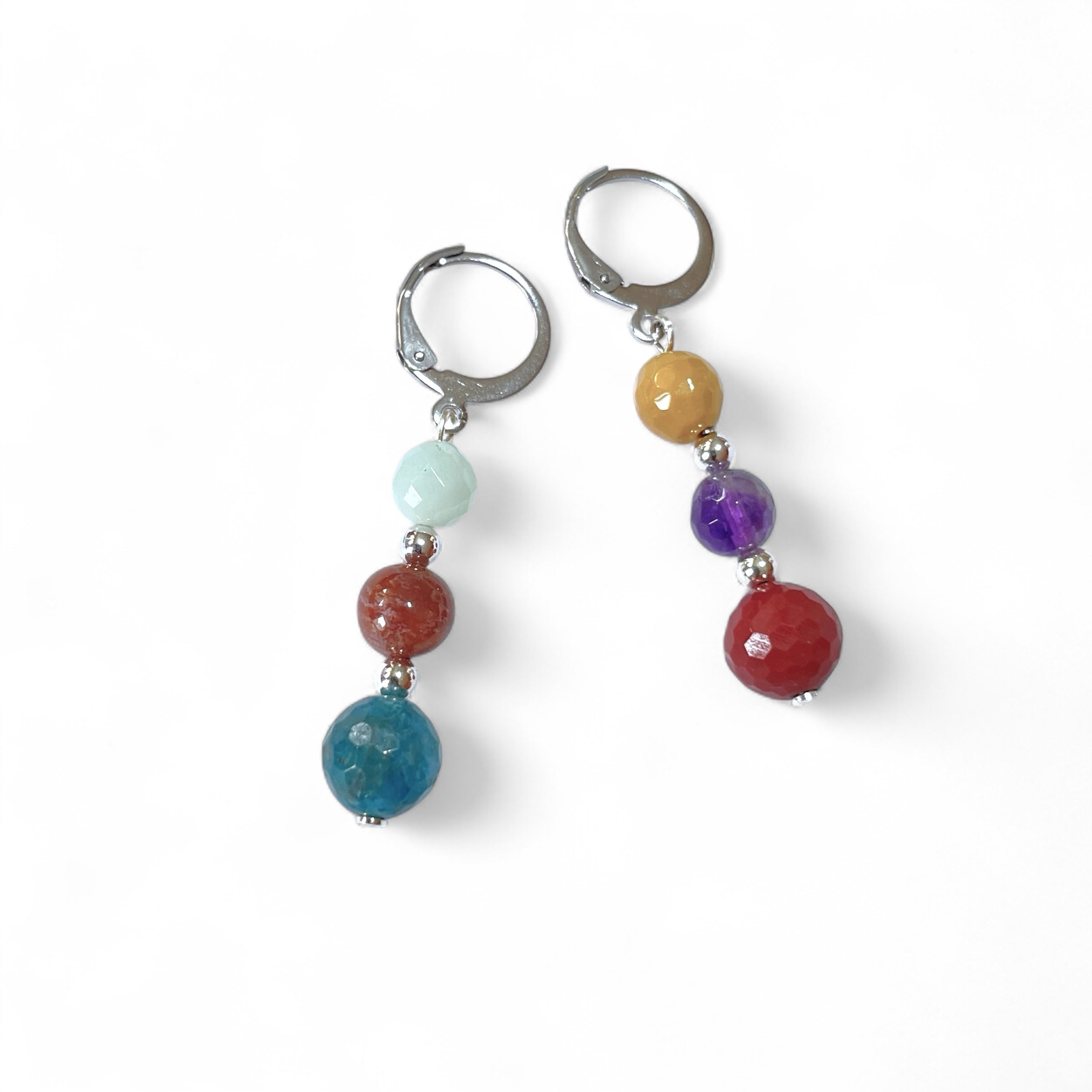 Boucles d'oreilles pendantes argentées en perles de pierres naturelles colorées sur fond blanc