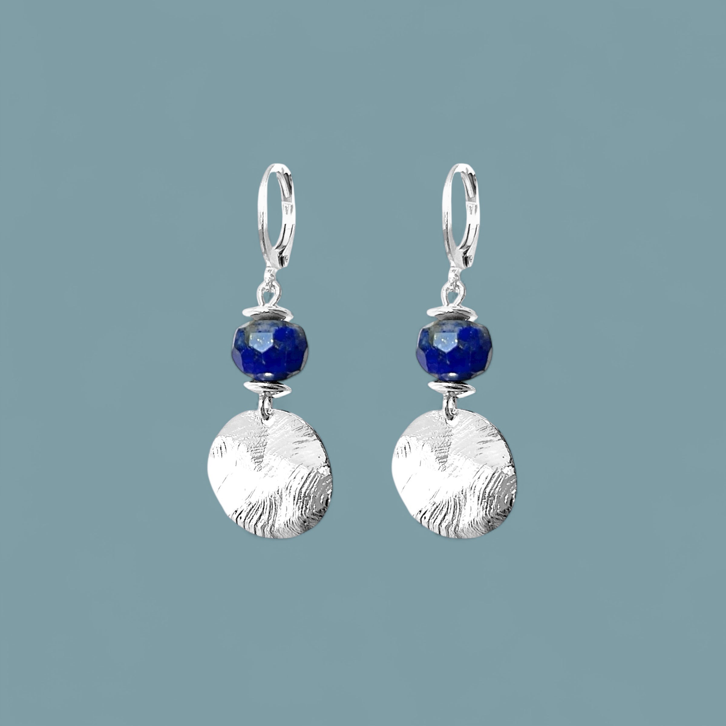 Petites boucles d'oreilles avec sequin rond en métal martelé argenté et perles de Lapis Lazuli, sur fond bleu gris