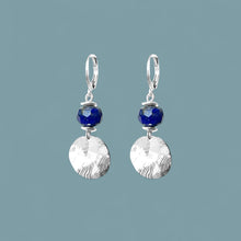 Charger l&#39;image dans la galerie, Petites boucles d&#39;oreilles avec sequin rond en métal martelé argenté et perles de Lapis Lazuli, sur fond bleu gris
