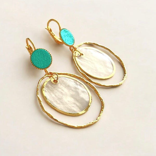 boucles d'oreilles dorées Nune modèle Bali Créoles Capiz en cuir turquoise métallisé sur fond beige