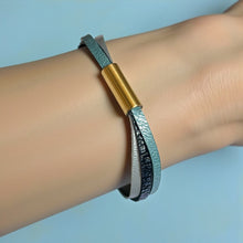 Charger l&#39;image dans la galerie, Cielo Bracelet femme tricolore à 3 liens avec fermoir aimanté doré, en cuirs bleu gris nacré, bleu glacier métallisé grainé, et champagne nacré, porté au poignet, sur fond bleu
