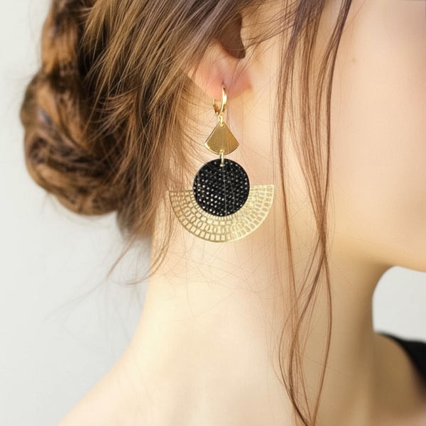 boucle d'oreille dorée Nune modèle Ephésia en cuir noir grainé irisé portée par une femme aux cheveux attachés