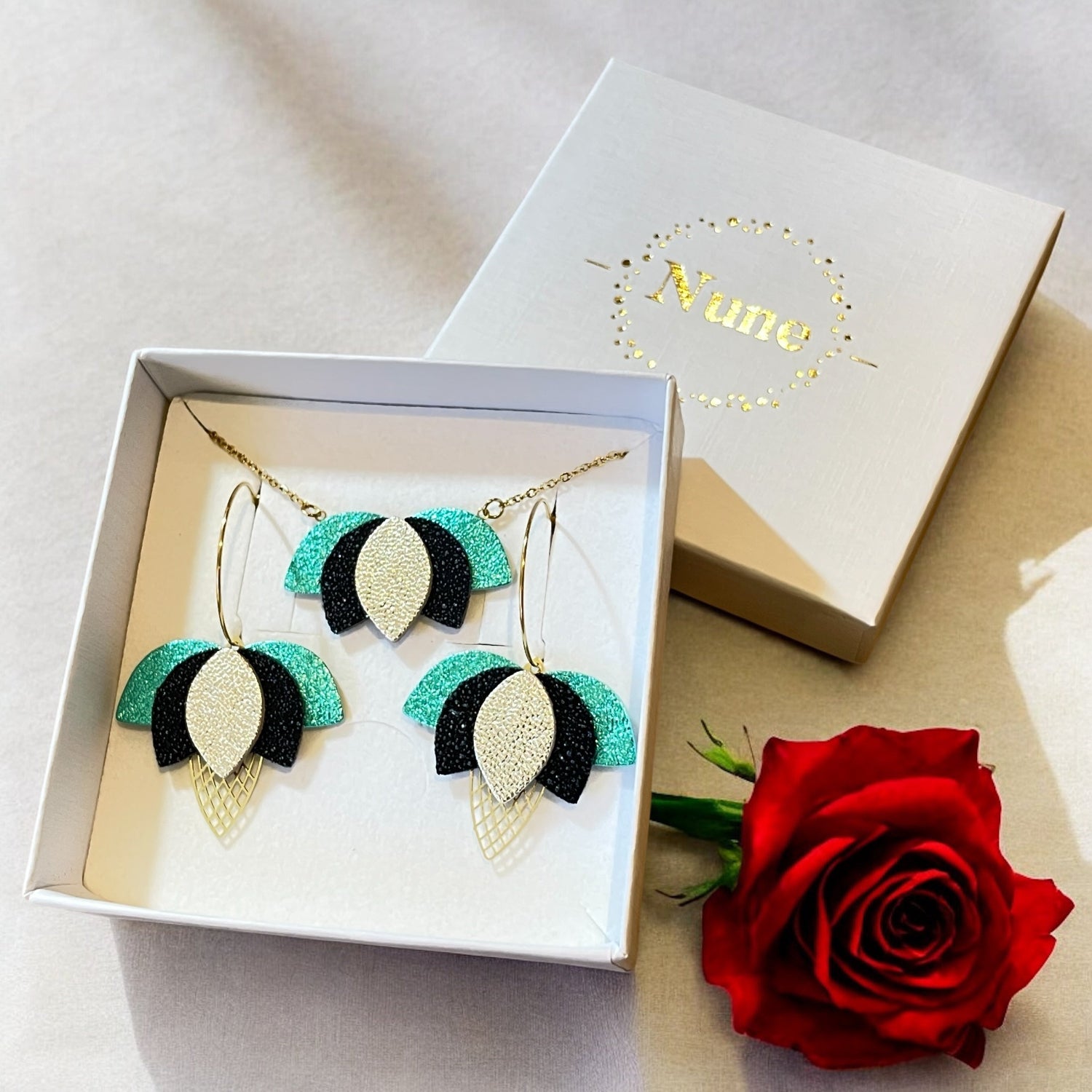 Parure collier et boucles d'oreilles créoles Lotus de Nune, présentée dans un écrin cadeau, pour un cadeau femme personnalisé fête des mères ou Saint Valentin.