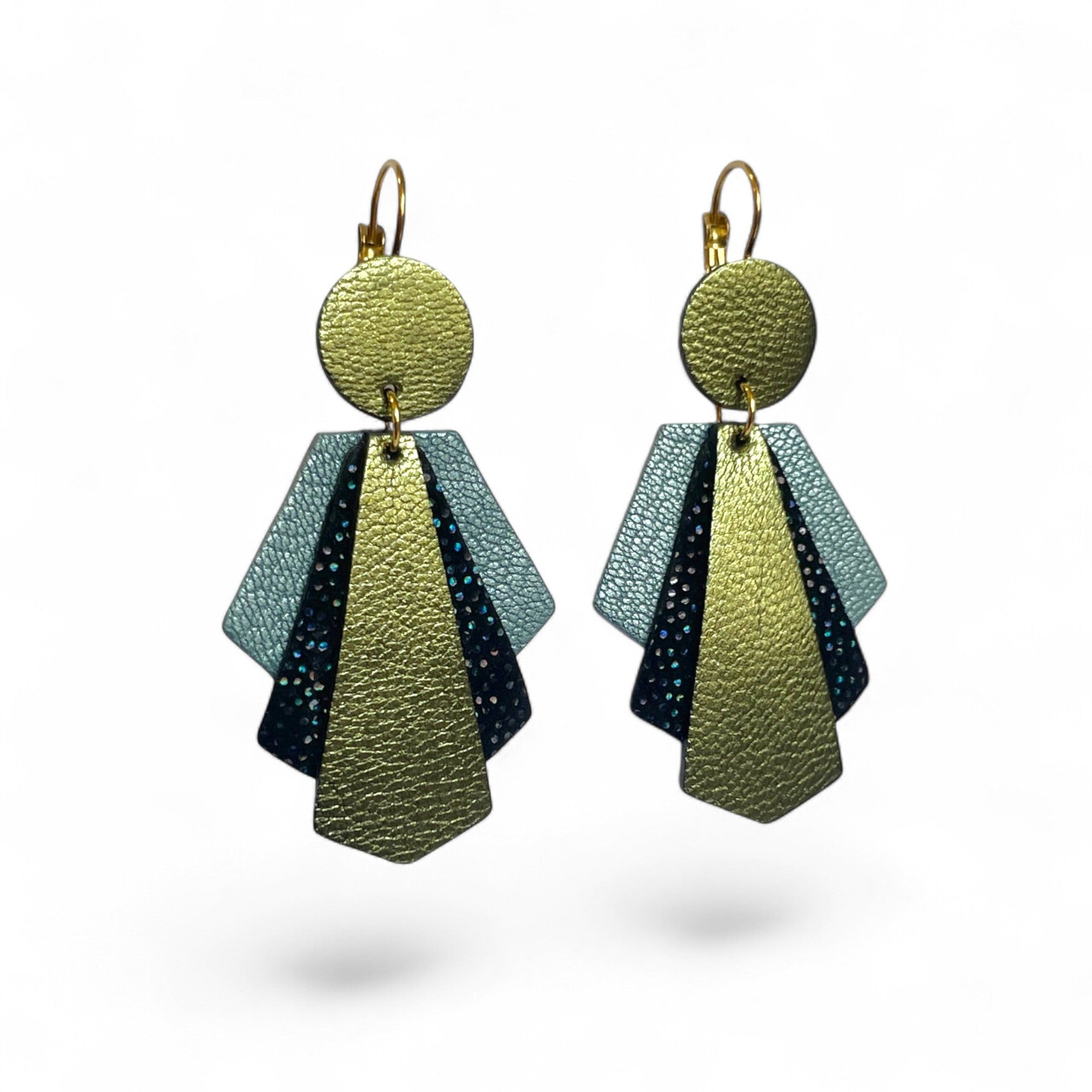 Grandes boucles d'oreilles dorées au design art déco, en cuirs bleu gris nacré, noir à pois holographiques et kaki métallisé, sur fond blanc