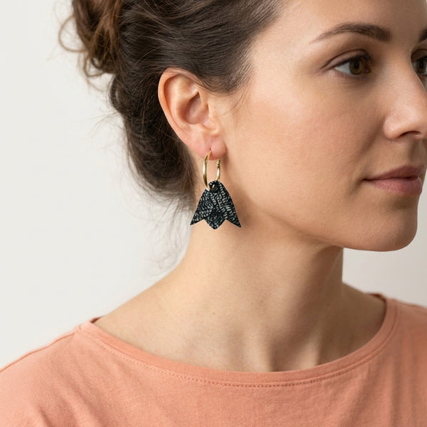 Boucles d'oreilles créoles dorées avec pendentifs légers en cuir noir brillant façon serpent en forme de tulipe, portées aux oreilles