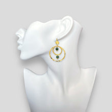 Charger l&#39;image dans la galerie, Grandes boucles d&#39;oreilles créoles dorées pendantes longues, style créoles, avec double anneau en métal martelé doré à l&#39;or fin et perles en agate indienne vertes, portées à l&#39;oreille sur un buste blanc
