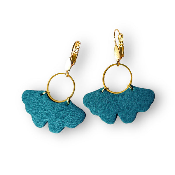 boucles d'oreilles dorées en forme de feuille de gingko en cuir vert canard, sur fond blanc