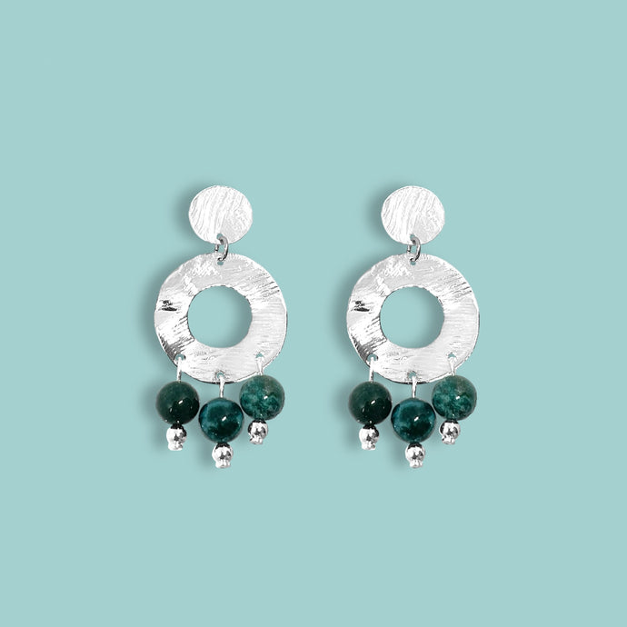 Petites boucles d'oreilles créoles à puces de forme ronde en métal martelé argenté et pierres naturelles de Jaspe océan vert foncé, sur fond vert pastel