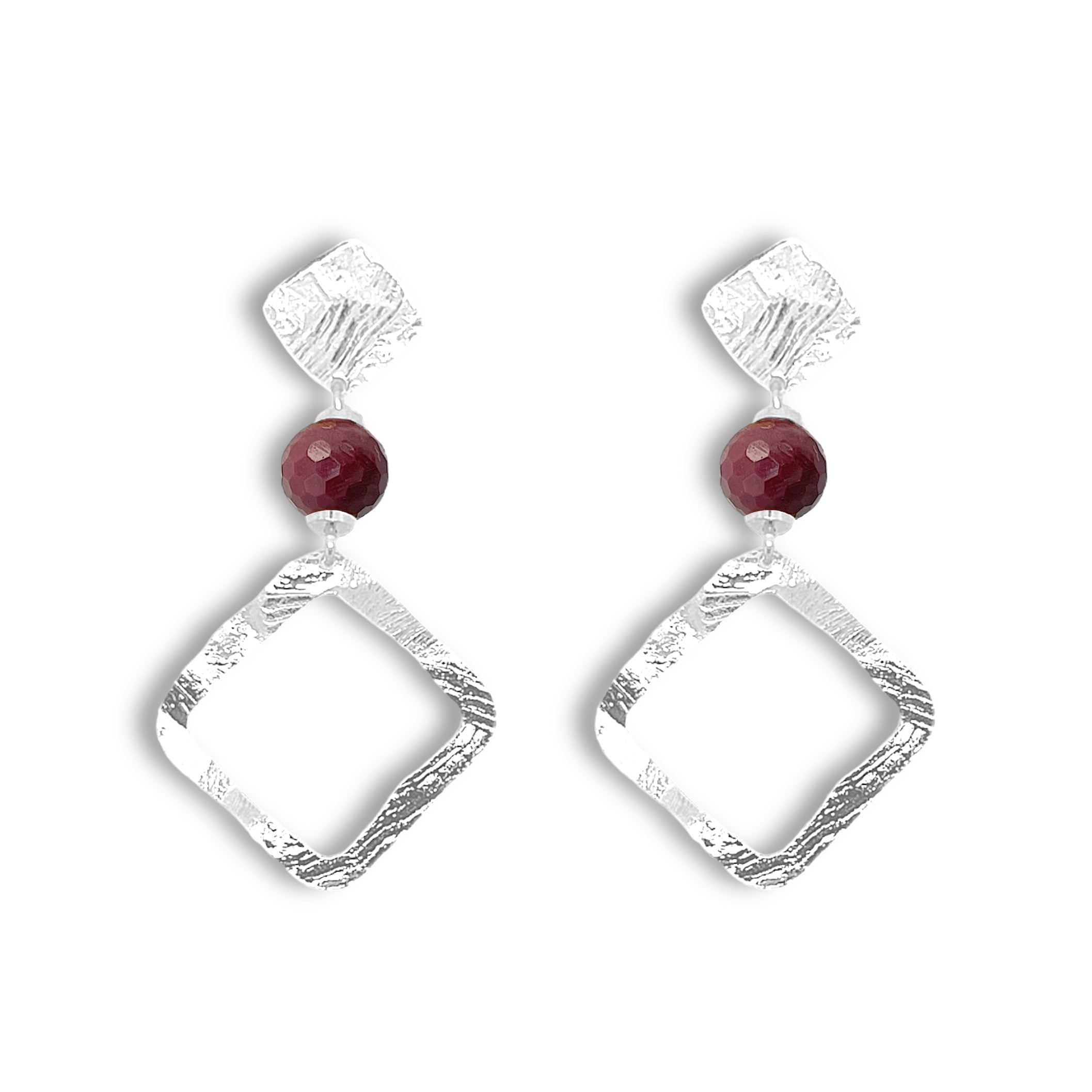 Boucles d'oreilles losanges sur puces en métal martelé argenté et perles de Mokaïte bordeaux, sur fond blanc