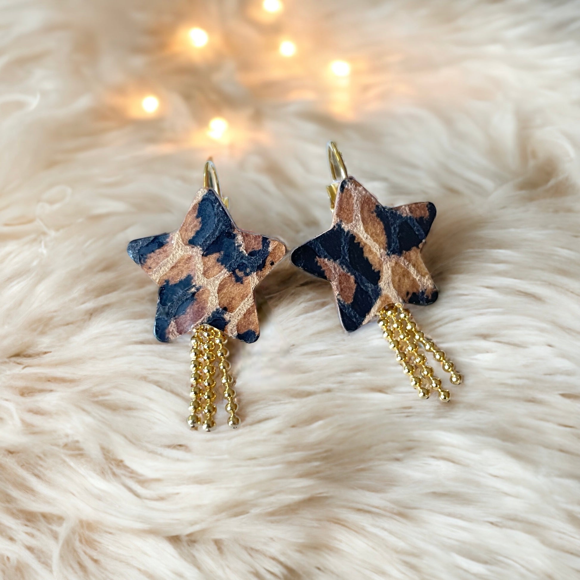 Boucles d'oreilles dorées Stella en forme d'étoiles, en cuir façon léopard, sur fond fourrure claire