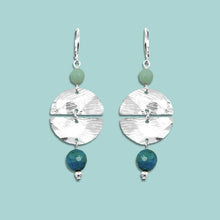 Charger l&#39;image dans la galerie, Boucles d&#39;oreilles pendantes de forme ronde avec 2 demi-lunes, en métal martelé argenté et perles d&#39;amazonite et d&#39;apatite bleue, sur fond vert pastel
