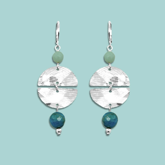 Boucles d'oreilles pendantes de forme ronde avec 2 demi-lunes, en métal martelé argenté et perles d'amazonite et d'apatite bleue, sur fond vert pastel