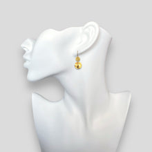 Charger l&#39;image dans la galerie, Petites boucles d&#39;oreilles dorées pendantes avec 2 petits sequins ronds en métal martelé, portées aux oreilles sur un buste blanc
