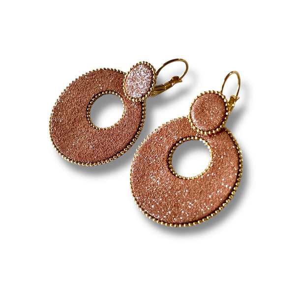 boucles d'oreilles créoles Nune modèle Céleste en forme de cercles en cuir brique pailleté argent cerclées de chaîne dorée, sur fond blanc