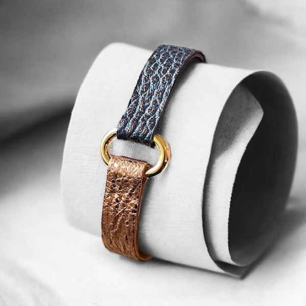 Bracelet bicolore à boucle dorée en cuirs recyclés or rose froissé et gris mordoré grainé, enroulé autour d'un tissu gris
