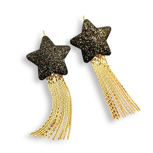 Nune Boucles d'oreilles légères SuperStella cuir pailleté, grandes étoiles en cuir noir pailleté or recyclé et leurs longues et fines chaînettes dorées, sur fond blanc