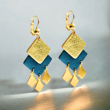Charger l&#39;image dans la galerie, Boucles d&#39;oreilles dorées Diamante en duo de losanges en cuirs doré et bleu nuit métallisé et pendentifs losanges dorés. Forme géométrique, style éthnique. Sur fond gris
