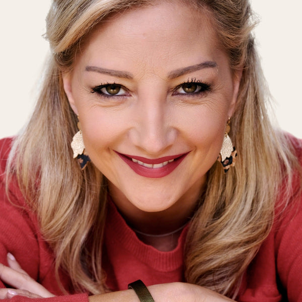 Femme blonde portant les paire de Boucles d'oreilles style bohème-chic, dorées à l'or fin, en forme de flammes en cuirs recyclés doré antique mat et façon léopard