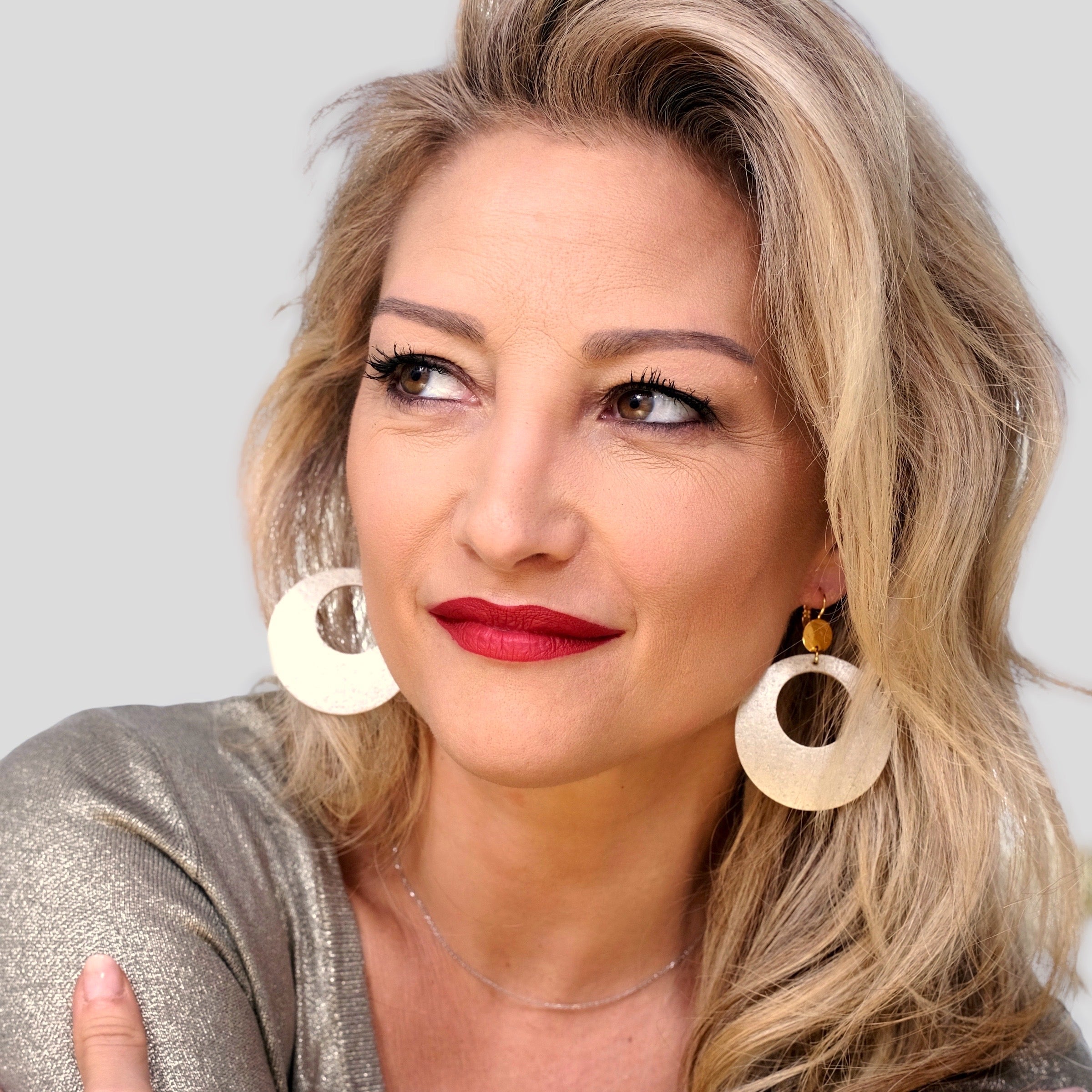 Femme blonde portant des grandes boucles d'oreilles créoles Zoa au style vintage en liège doré antique