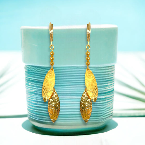 Longues boucles d'oreilles fines avec double pointes en métal martelé doré à l'or fin, sur un pot vert